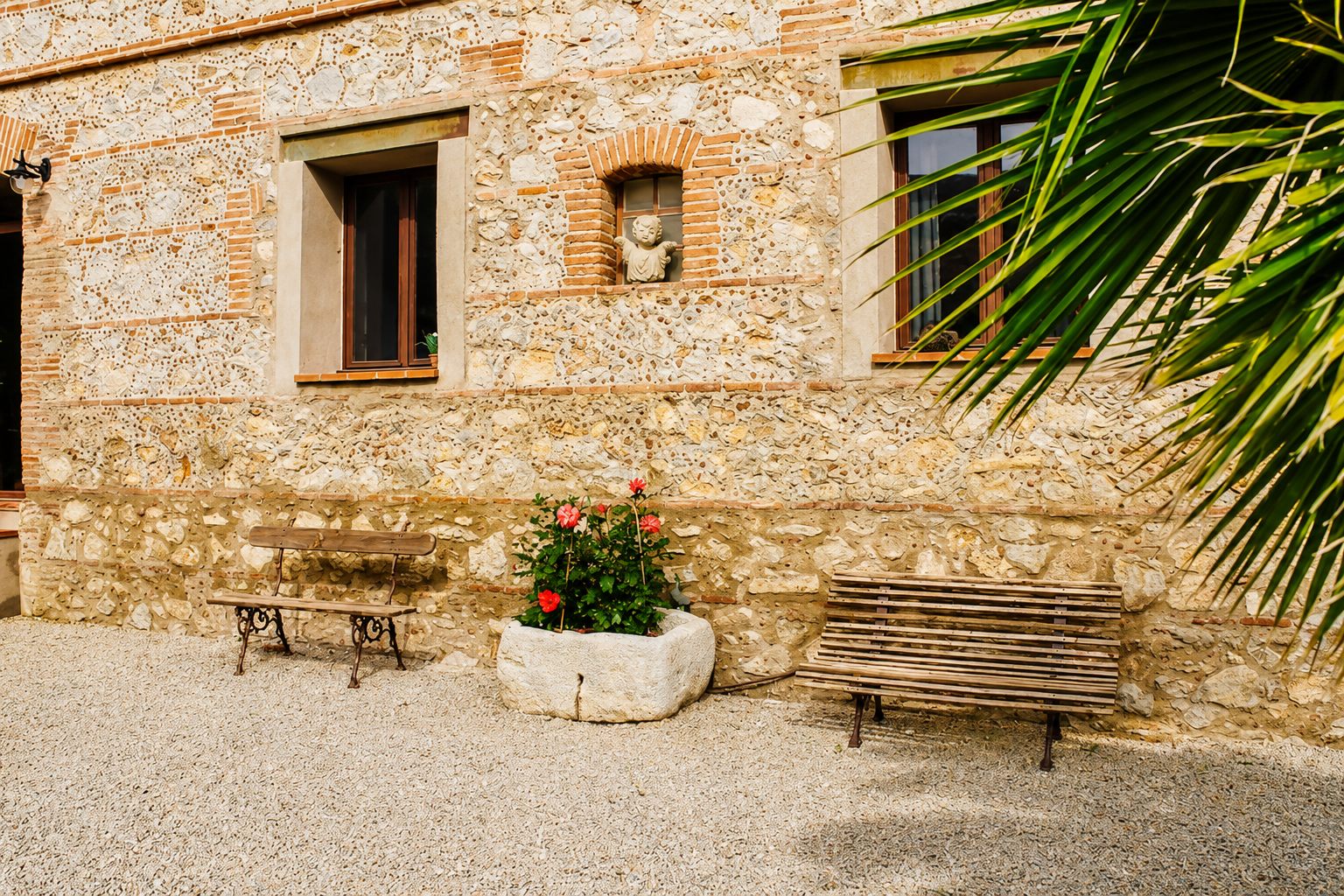 Cour en pierre avec bancs au Mas du Domaine de Montcalm à Thuir