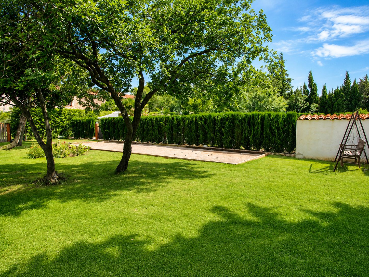 Jardin avec terrain de pétanque et balançoire au Domaine de Montcalm à Thuir